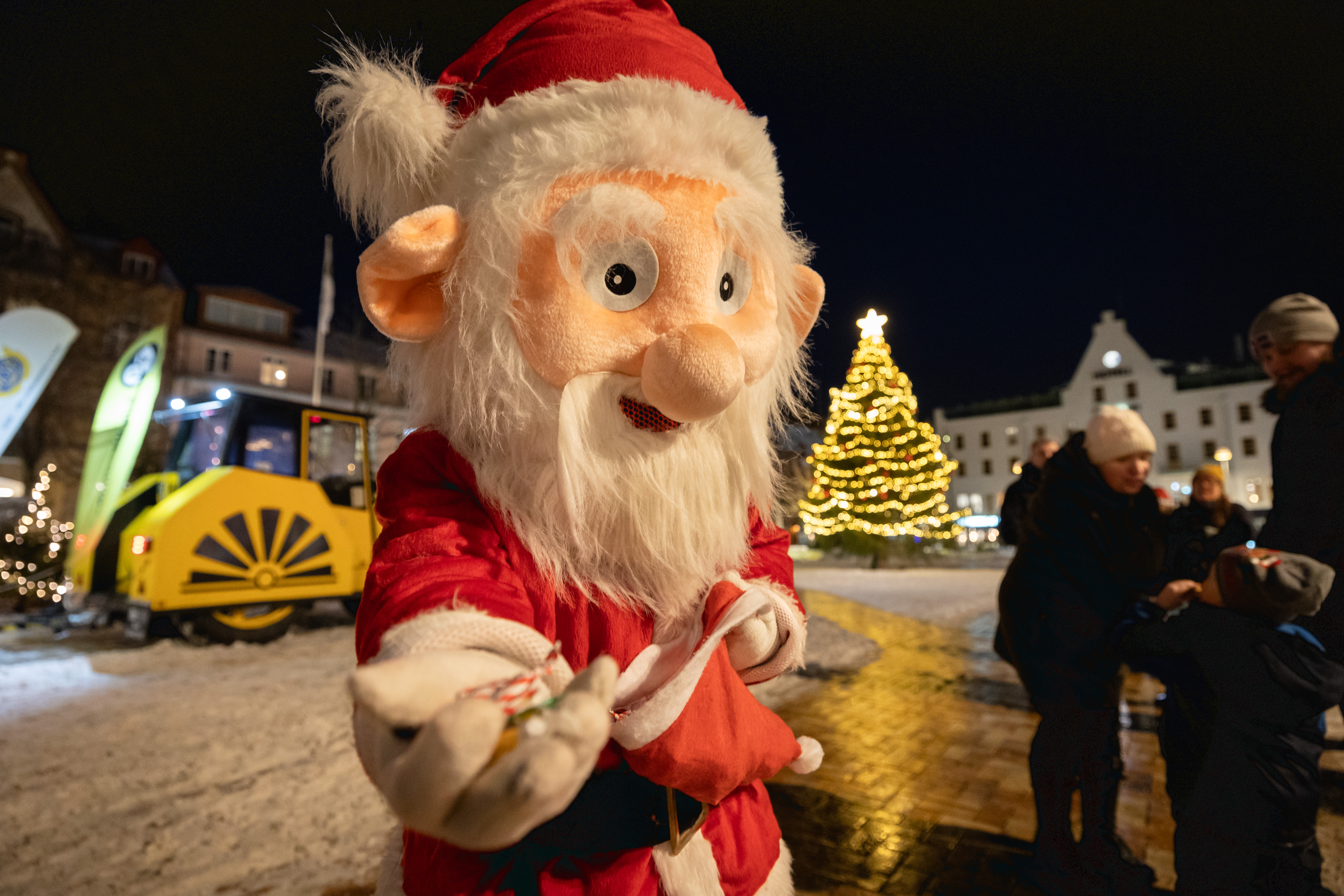 En tomtemaskot på Stora torg i Eslöv bjuder på godis.