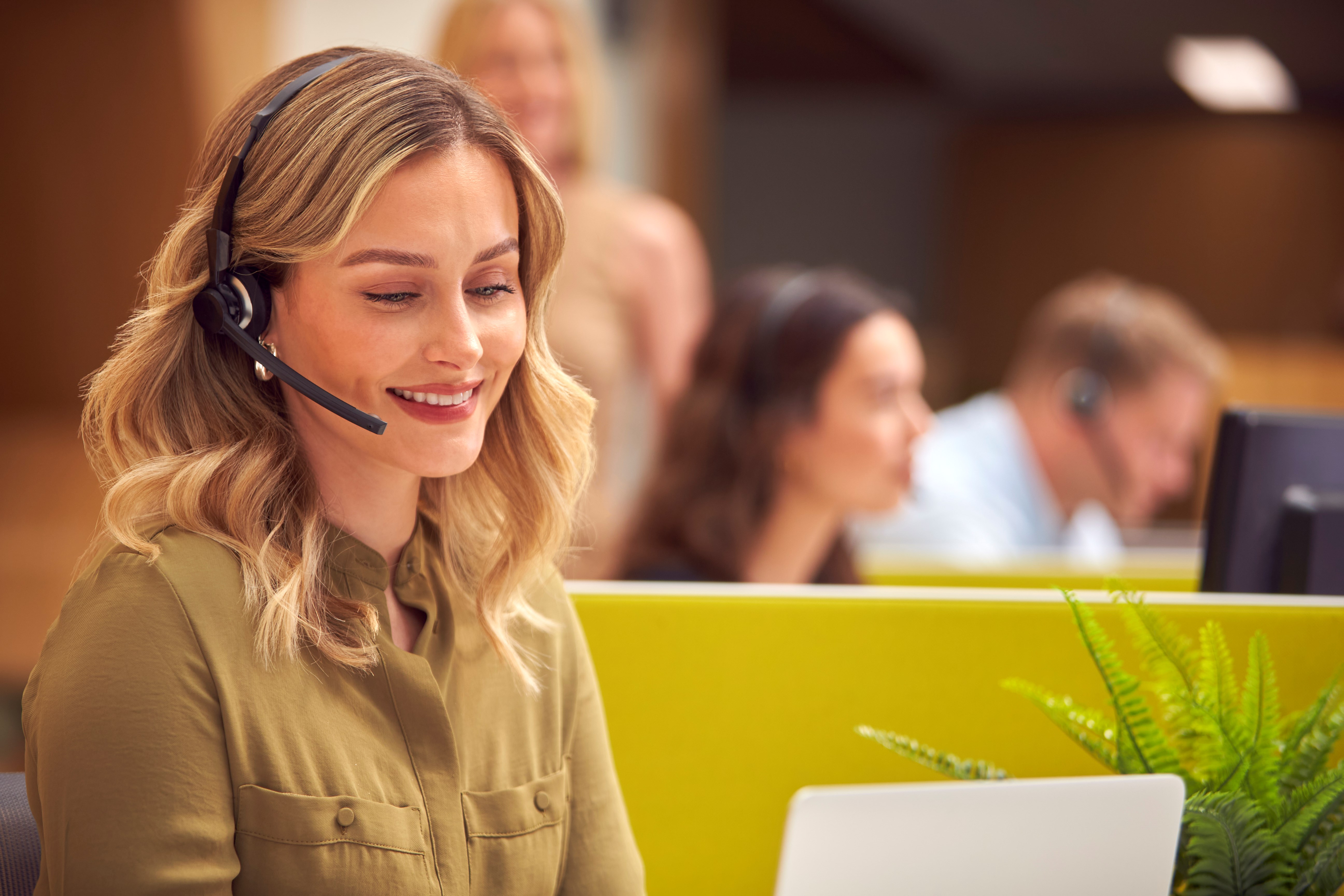 Kvinna i kundtjänst talar i telefon med headset